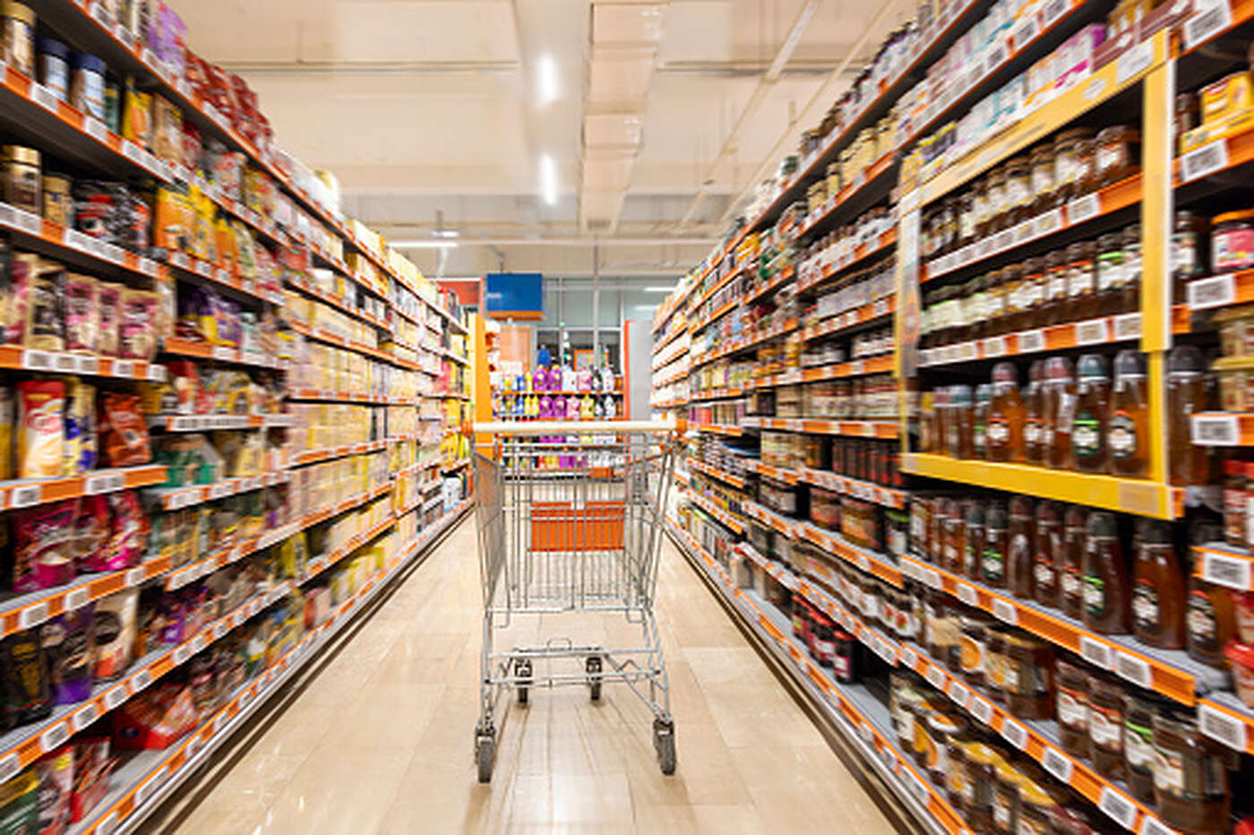 A brightly lit supermarket aisle with fully stocked shelves